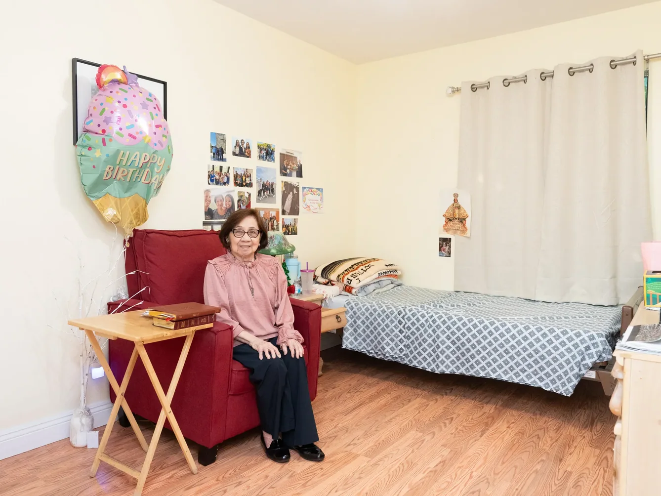 Resident seated in her private bedroom decorated with family photos and personal belongings